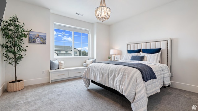 bedroom with baseboards, visible vents, light colored carpet, and an inviting chandelier