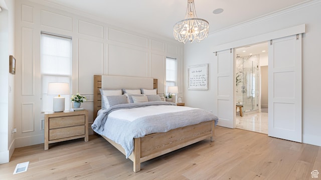 bedroom with a chandelier, light wood finished floors, visible vents, and crown molding