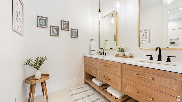 full bathroom featuring baseboards, a sink, and double vanity