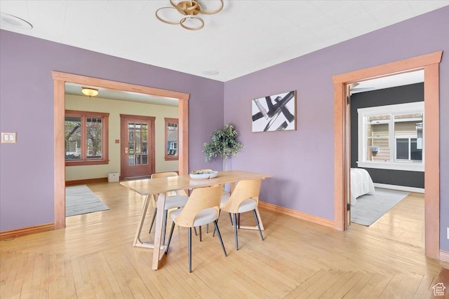 dining area featuring light wood-style flooring and baseboards