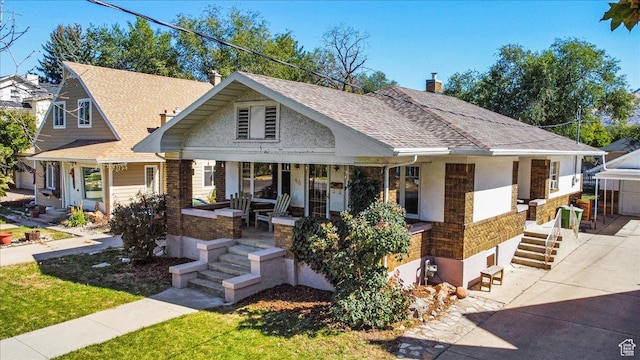 view of front of house with roof with shingles, a chimney, and covered porch