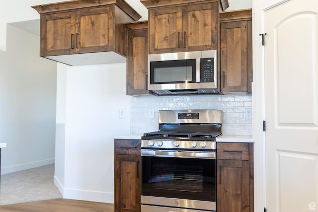 1403 E 1230 S Unit 45, Garland, UT 84312 - kitchen with backsplash, baseboards, stainless steel appliances, and light countertops
