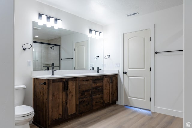 1403 E 1230 S Unit 45, Garland, UT 84312 - bathroom featuring a sink, a stall shower, toilet, visible vents, and wood finished floors