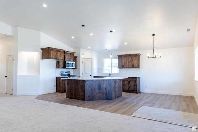 1403 E 1230 S Unit 45, Garland, UT 84312 - kitchen featuring a center island, dark brown cabinetry, backsplash, a chandelier, and appliances with stainless steel finishes