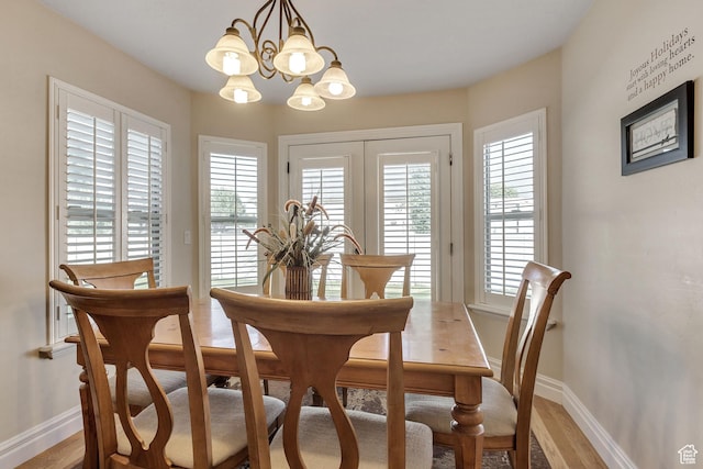 dining room with light wood-style flooring, a wealth of natural light, and baseboards