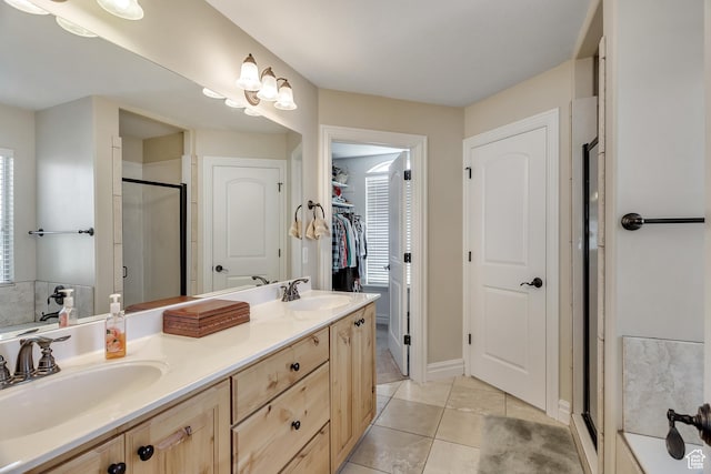 bathroom with tile patterned flooring, a sink, double vanity, and a stall shower