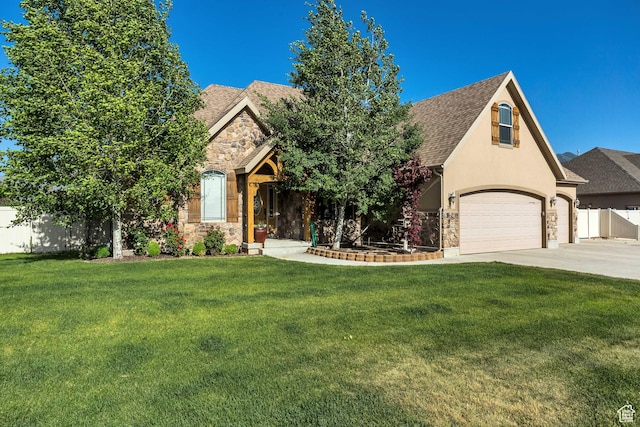 view of front of property featuring stone siding, a shingled roof, fence, and a front yard