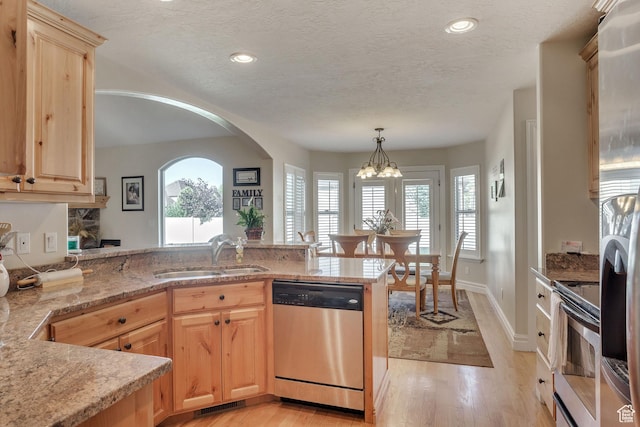 kitchen with light wood-type flooring, stainless steel appliances, light brown cabinets, and a sink