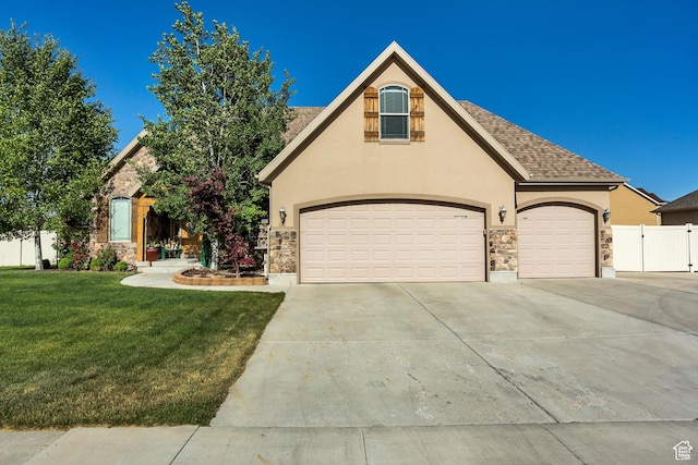view of front of home with concrete driveway, stone siding, stucco siding, and a front yard