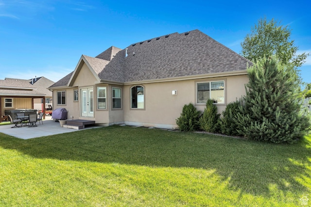 back of house featuring a patio area, a shingled roof, french doors, a yard, and stucco siding