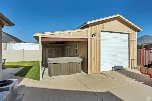 back of property with a hot tub, a patio, central AC unit, and fence