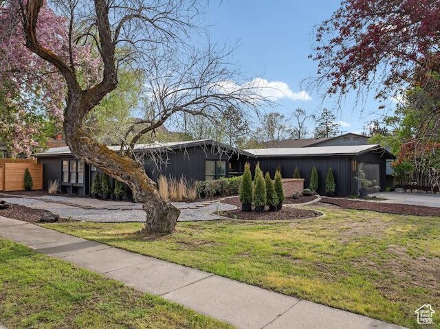 976 E Hyland Lake Dr, Murray, UT 84121 - mid-century inspired home with an attached garage, a front lawn, fence, and driveway