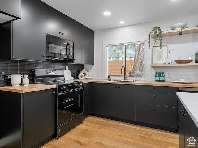 976 E Hyland Lake Dr, Murray, UT 84121 - kitchen with wooden counters, dark cabinets, a sink, light wood-type flooring, and black appliances