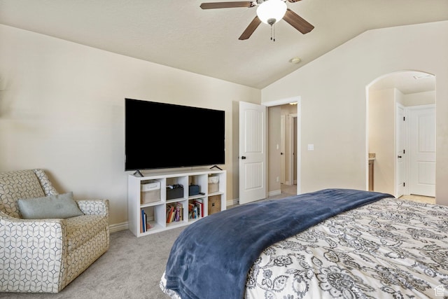 bedroom featuring vaulted ceiling, a ceiling fan, arched walkways, light colored carpet, and baseboards