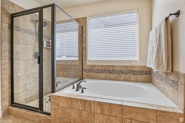 bathroom with a bath and a stall shower