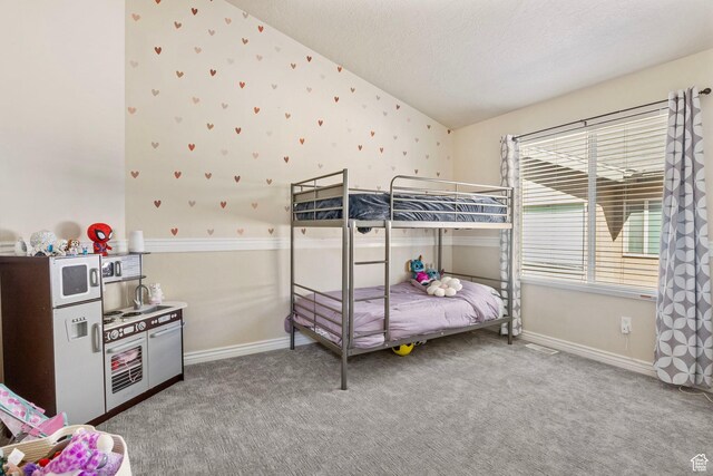 bedroom featuring a textured ceiling, vaulted ceiling, carpet floors, and baseboards