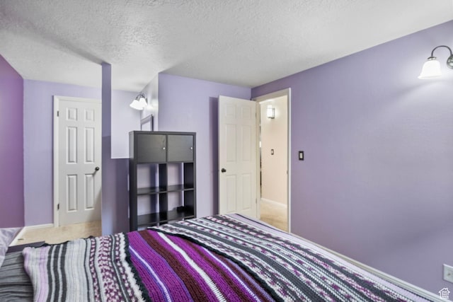 carpeted bedroom with baseboards and a textured ceiling