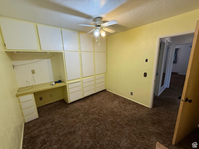 unfurnished bedroom featuring dark colored carpet and a textured ceiling