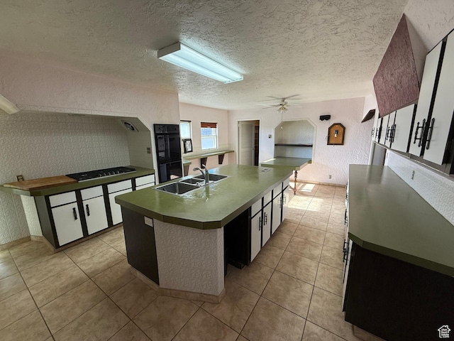 kitchen featuring a ceiling fan, light tile patterned floors, a sink, and black appliances