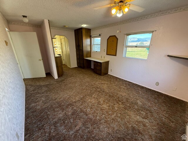 interior space featuring arched walkways, carpet floors, a ceiling fan, and a textured ceiling
