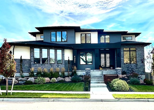 view of front of house with a porch, stone siding, and a front yard