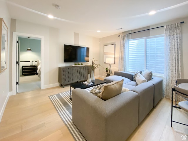 living area featuring recessed lighting, light wood finished floors, and baseboards