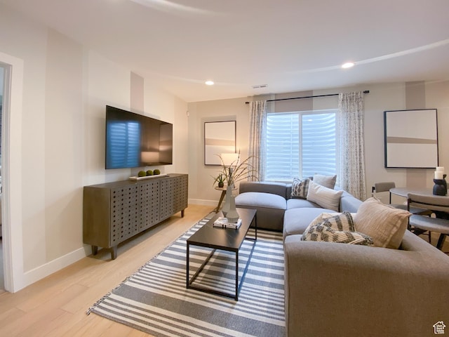living room featuring recessed lighting, light wood-style floors, and baseboards
