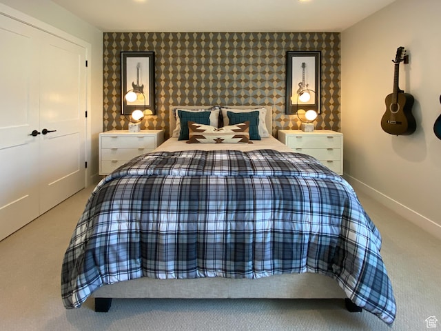 bedroom with baseboards, carpet flooring, an accent wall, and wallpapered walls