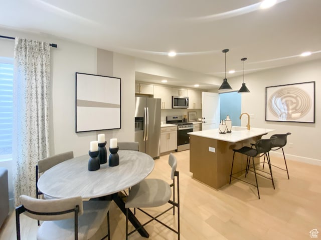 dining room with recessed lighting, light wood-style floors, and baseboards