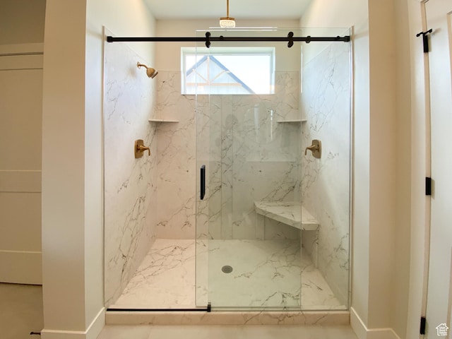 bathroom featuring baseboards and a marble finish shower