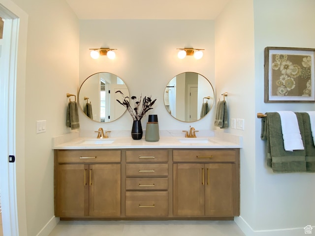 bathroom with double vanity, baseboards, and a sink