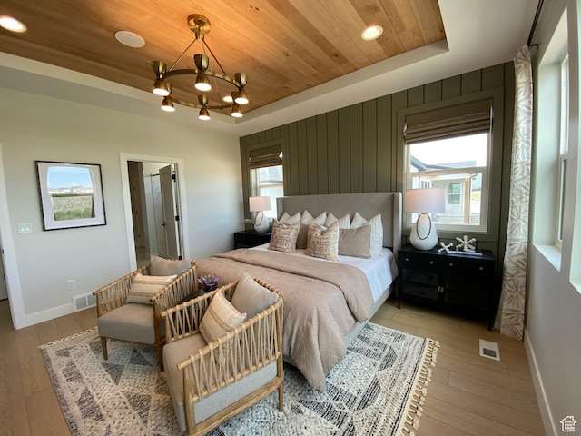 bedroom featuring a chandelier, light wood-style flooring, visible vents, and wood ceiling