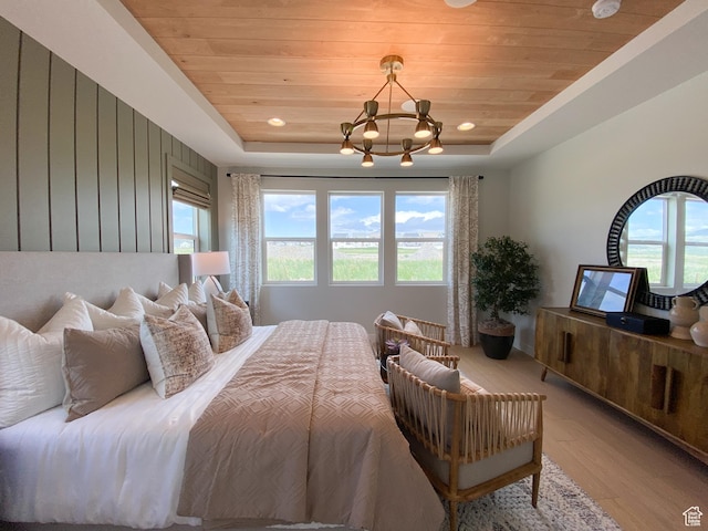 bedroom featuring wood ceiling, wood finished floors, and a tray ceiling