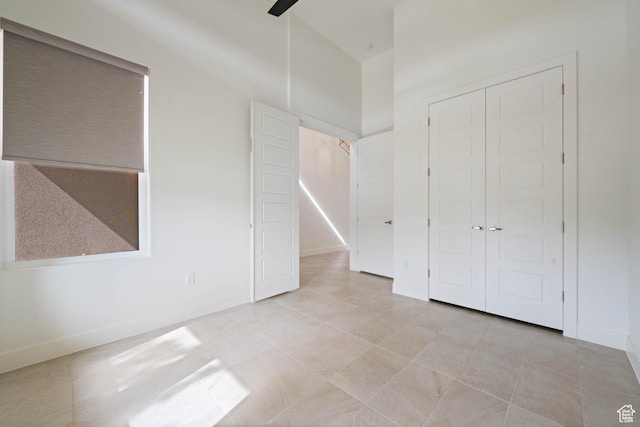 unfurnished bedroom featuring a closet, baseboards, and light tile patterned floors