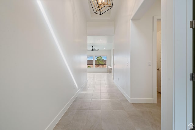 corridor with baseboards and light tile patterned floors
