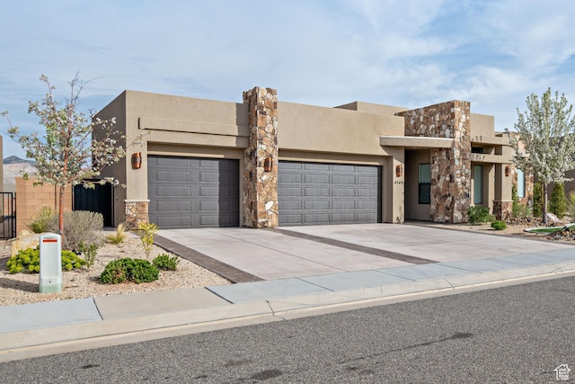 view of front facade with an attached garage, stone siding, stucco siding, and driveway