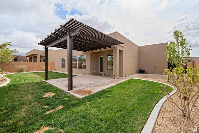 back of house featuring a pergola, a lawn, fence private yard, and stucco siding