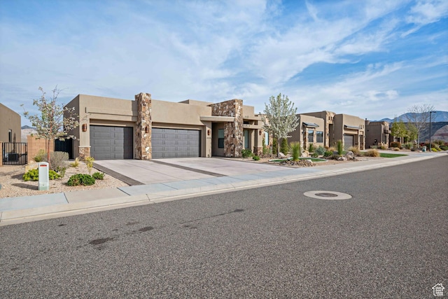 southwest-style home with concrete driveway, fence, a garage, stucco siding, and a residential view