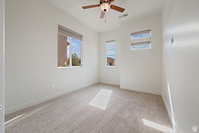 unfurnished room featuring baseboards, visible vents, carpet floors, and ceiling fan