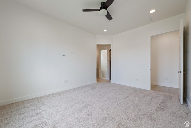 unfurnished bedroom featuring light carpet, baseboards, and recessed lighting