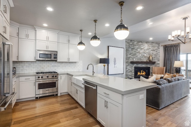 1166 W Cadence Ct, Kamas, UT 84036 - kitchen featuring a sink, decorative backsplash, open floor plan, stainless steel appliances, and a peninsula