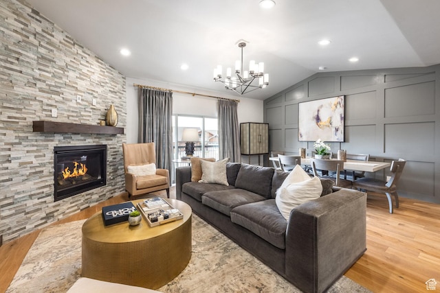 1166 W Cadence Ct, Kamas, UT 84036 - living room featuring lofted ceiling, an inviting chandelier, light wood-style floors, a decorative wall, and a fireplace
