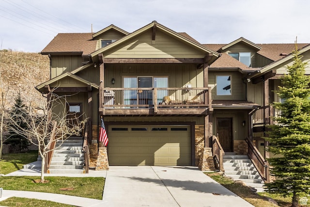 1166 W Cadence Ct, Kamas, UT 84036 - view of front facade with stone siding, concrete driveway, an attached garage, a balcony, and board and batten siding