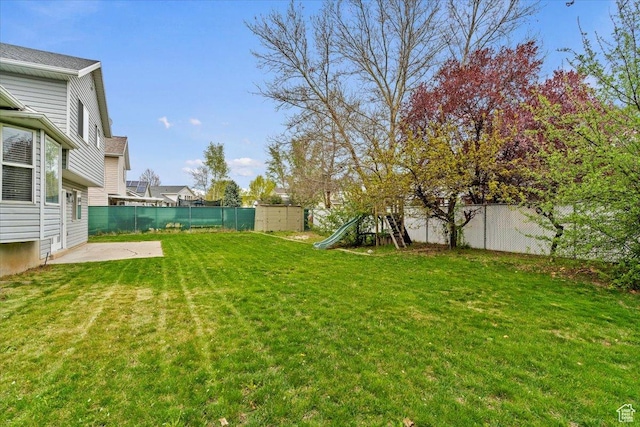 view of yard with a patio, a fenced backyard, and a playground