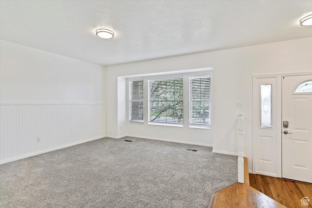 entryway with wainscoting and visible vents