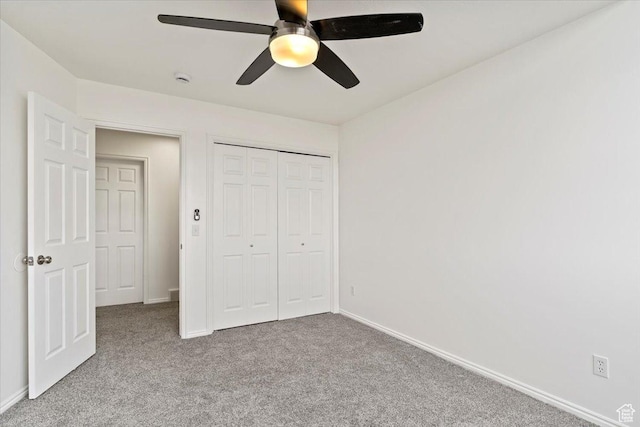 unfurnished bedroom with baseboards, carpet flooring, and a closet