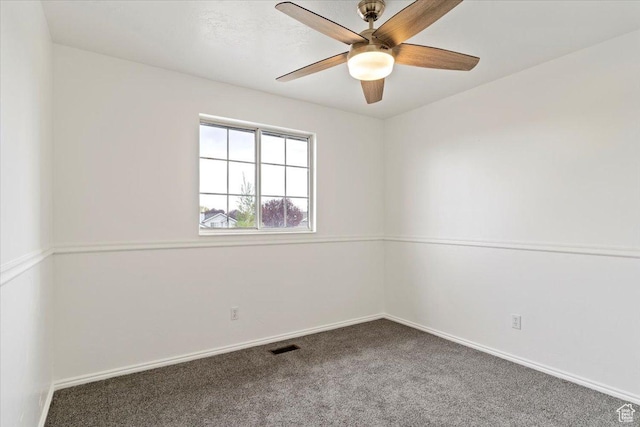 carpeted spare room featuring visible vents, a ceiling fan, and baseboards