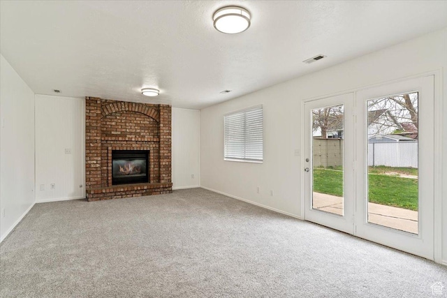 unfurnished living room with visible vents, carpet flooring, and a healthy amount of sunlight