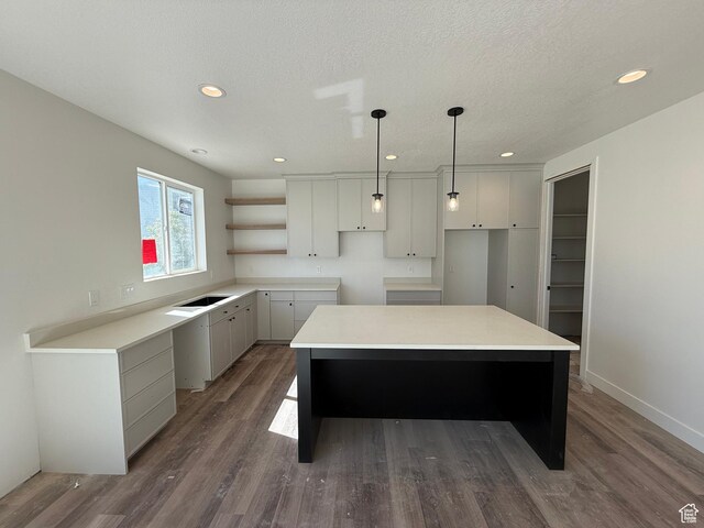 kitchen with a center island, dark wood-style floors, recessed lighting, open shelves, and decorative light fixtures