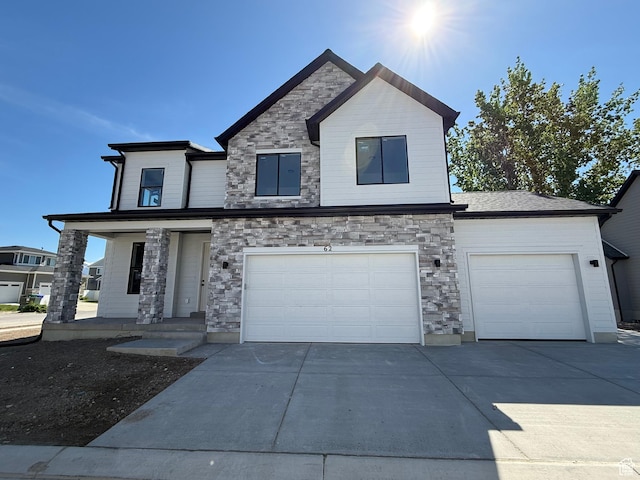 view of front of property featuring concrete driveway, stone siding, an attached garage, and a porch